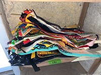 Stack of over 30 vintage travel pennants folded and stacked, showing colorful felt, various place names.