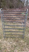 Front view of the gray metal shoe rack showing horizontal bars for shoe storage in outdoor setting
