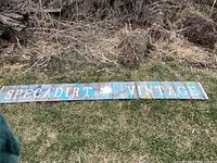 Front view of metal sign on grass, showing 'SPECADIRT VINTAGE' text with central emblem
