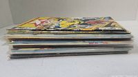 Side view of stack of comic books showing edges and thickness.