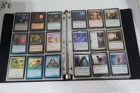 Two page spread of Magic The Gathering cards in plastic sleeves inside a binder showing a variety of cards.