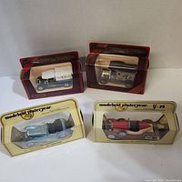 Four diecast cars in original packaging: two with red blister packs and two with yellow packaging from Models of Yesteryear series.