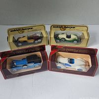Four vintage Matchbox Models of Yesteryear die-cast cars in original display cases, showing front and side views of the models.