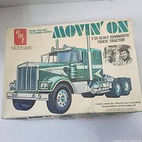 Front view of the box showing the full illustration of a teal and white Kenworth truck tractor and text indicating it is a 1/25 scale model from the NBC television series 'Movin' On'.