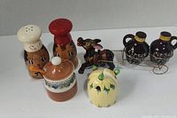 Photo showing all six pieces including salt and pepper shakers, honey pot, pumpkin, donkey figure, and jug shakers in metal holder