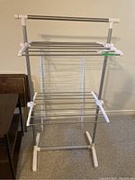 Photo showing front side of one metal drying rack made of stainless steel rods and white plastic connectors