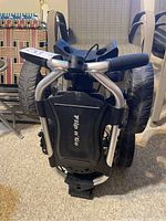 Folded view of the Flip n Go golf cart showing black handle grips and silver frame.