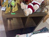 IKEA four storage compartment shelving unit with decorations on top and visible wood grain finish.