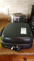 Hamilton Beach electric griddle on counter with Black and Decker toaster in background