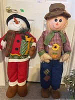 Photo of both seasonal figures, snowman on the left and scarecrow on the right, showing full size and details