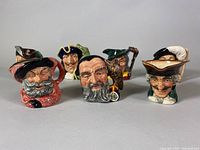 Group view of 7 Royal Doulton toby mugs depicting various characters with detailed painted faces and costumes