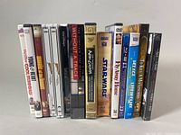 Photo showing a lineup of 16 Blu-ray and DVD movie cases featuring vintage children's and classic films including Star Wars, E.T., To Kill a Mockingbird, and others.