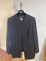 Front view of the black wool blazer on Giorgio Armani hanger