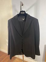 Front view of black wool blazer on hanger with Giorgio Armani label, shows three button front closure and classic lapel collar.