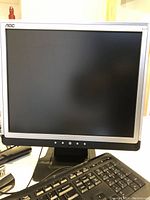 AOC LCD monitor with silver frame, keyboard visible in front.