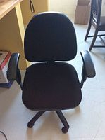 Front view of black office chair showing seat, backrest, and armrests