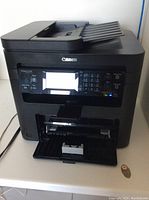 Front view of Canon ImageClass MF217wn multifunction printer showing LED display, keypad, input and output trays.
