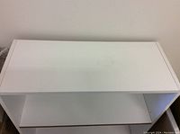 Top view of white bookshelf showing smooth top surface and rectangular shape.