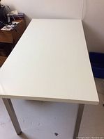 Top-down view of the white computer desk showing surface and metal legs.