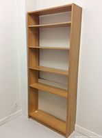 Full view of a simple wooden bookshelf with five shelves and no backing panel, showing the overall size and condition of the piece.