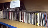 Shelf with many classical music CDs in jewel cases, some stacked horizontally and vertically. The spines show multiple titles by various composers.