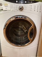 Front view of closed GE front loading washing machine showing control panel and door.