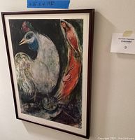 Front view of the framed Marc Chagall Le Coq poster hanging on a wall with size label showing 26 x 19 3/4 inches.