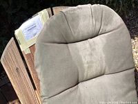 Close-up of the grey all-weather cushion on the teak Adirondack chair showing weathered fabric.