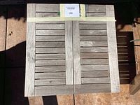 Top view showing the square slatted teak wood tabletop with a pale, weathered finish.