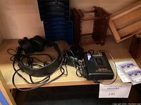 Photo of headphone, cassette player, and wooden cassette organizer shelf.