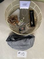 Wide view of boxed assorted costume jewelry items including Nolan Miller necklace, scrunchie, bracelet, earrings, and necklace with leaf pendant