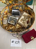 Top view of the hat box filled with assorted jewelry, brooches, and accessories.