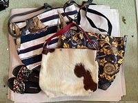 Photo of three bags and a pair of embroidered shoes laid flat on the floor