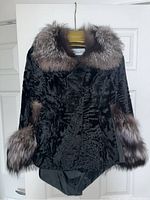 Front view of black vintage fur cape showing textured fur body with large fox fur collar and cuffs.