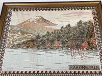 Full view of framed tapestry depicting Mount Fuji, a lake, trees, and red torii gate, with 'HAKONE FUJI' text along bottom.