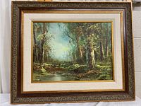 Full view of the framed oil painting, showing the forest landscape and overall condition of frame and matting.