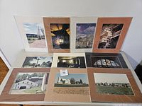 Overview of 14 matted photo prints showing local Pennsylvania churches, barns, crosses, and rural landscapes arranged on floor against wall