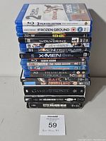 Stack of Blu-ray and DVD movies and TV series in cases including George of the Jungle/Frozen Ground collection, Kick-Ass 2, Wolverine, X-Men First Class, Dexter seasons, The Lost Boys, Prodigy, Bait 3D, Zombieland, Game of Thrones season 1, The Walking Dead season 1 and 3.