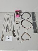 Full lot of assorted costume jewelry displayed including bracelets, necklaces, earrings, and Betsey Johnson jewelry box.