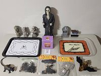 Overview of Halloween themed decoration items on a white surface including platters, figurines, party picks, and small spooky props.