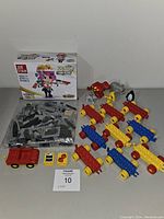 Photo showing unopened JIE STAR League of Big Heads boxed set with 279 pieces and assorted loose Lego parts including animal figures and Duplo blocks.