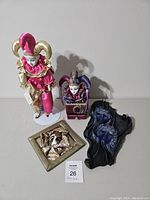 Lot includes Victoria musical jester doll, musical jester box, leather mask art, and ceramic mask art.