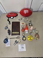 Front view showing all assorted promotional items including keychains, magnetic pins, and a football.