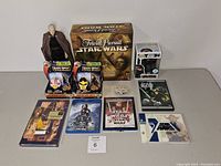 Full lot overview showing Star Wars Trivial Pursuit game, figurine, games, DVDs, Funko Pop figure, and collectibles