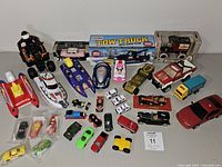 Wide view of the assortment showing boats, cars, trucks, and boxed items