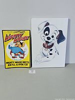 Photo of the Mighty Mouse poster and 101 Dalmatians canvas showing their size and condition