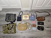 Full assortment of women's bags, purses, and wallets, displaying different sizes, colors, and styles, arranged on the floor