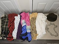 Full lot showing all scarves laid out in a row with belt and hat on the side
