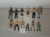 Full top-down view showing 12 assorted wrestling action figures arranged in two rows on a neutral background.
