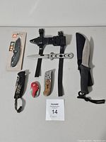 Overview of six assorted cutters and knives shown with one fixed blade knife with leg strap for scuba diving and several folding cutters of various styles and brands.